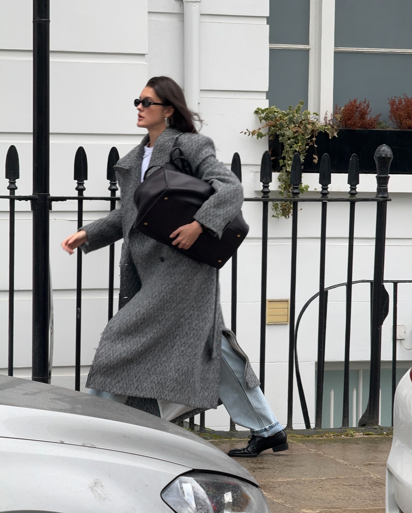 Influencer @sobalera wears a grey coat with blue jeans and black shoes.