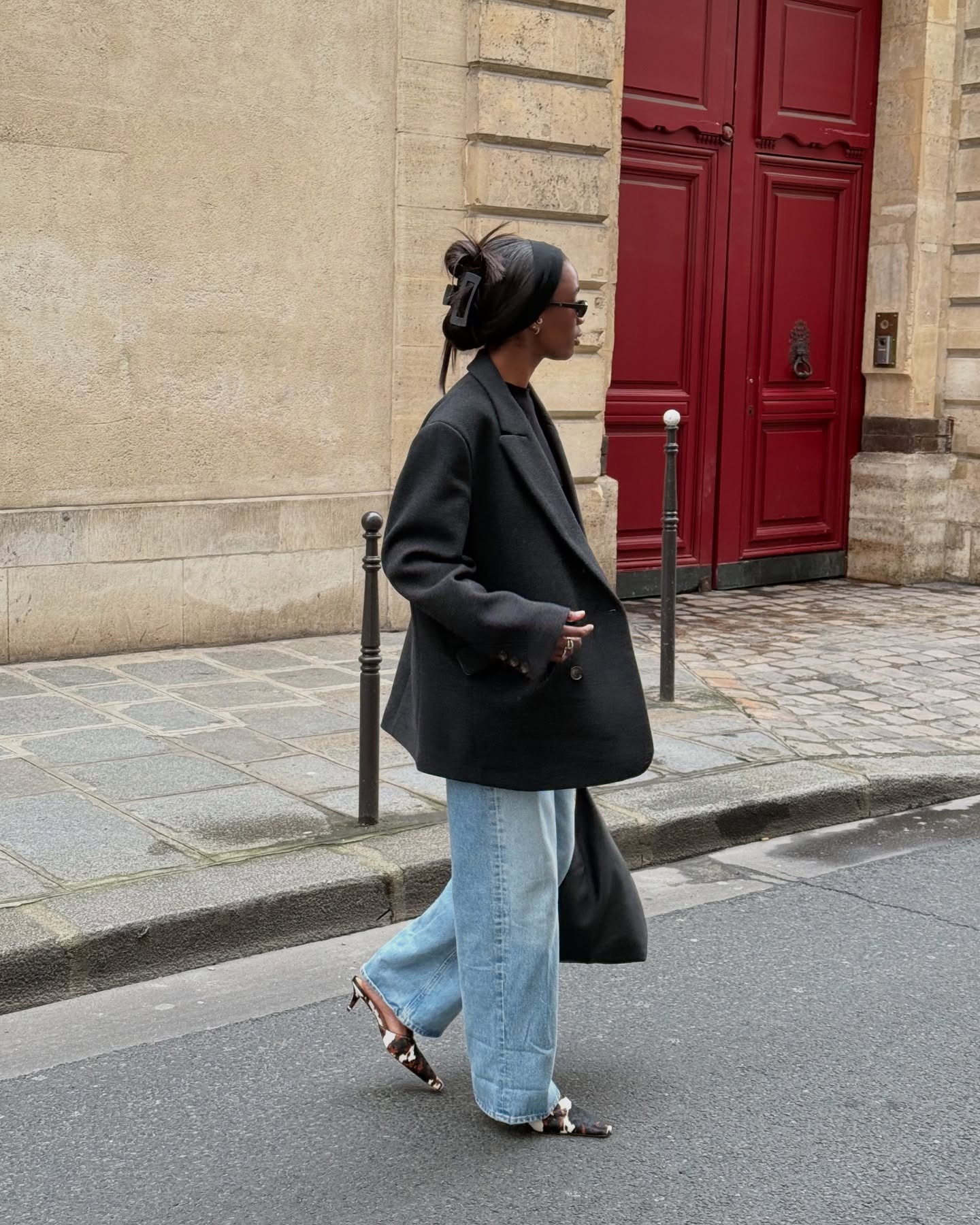 Woman wears an oversize blazer, baggy jeans, and pointy toe pony hair slingback heels on the street.